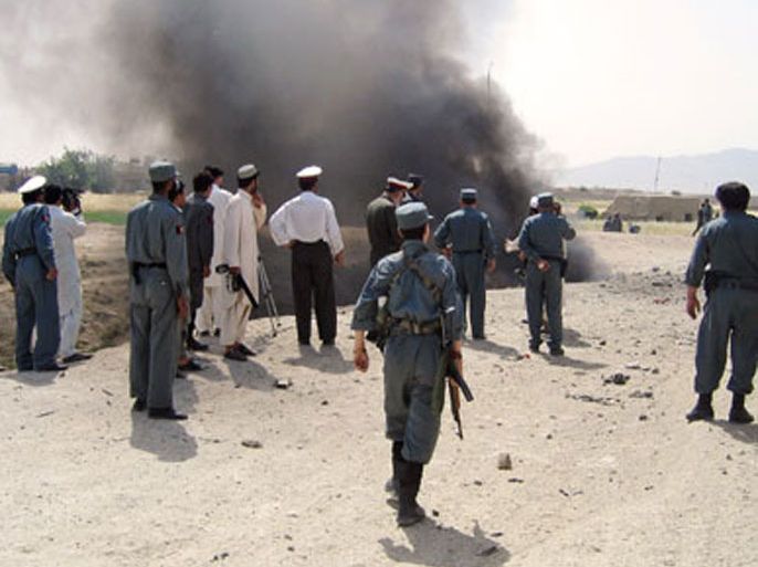 Afghan policemen stand guard at the site of a bomb blast, in Kandahar, 17 May 2007. A double bombing tore through the centre of Afghanistan's southern city of Kandahar,