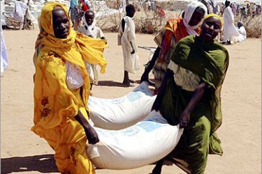 . AFP / A picture taken by the World Food Programme in February 2007 shows women from Sania's village carrying sacks of Sorghum near Nyala. Sudan faces the risk of further sanctions and isolation after unequivocally ruling out any