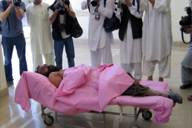 Afghan journalists take photographs of the dead body of the Taliban's top military commander Mullah Dadullah lies in Kandahar, 13 May 2007