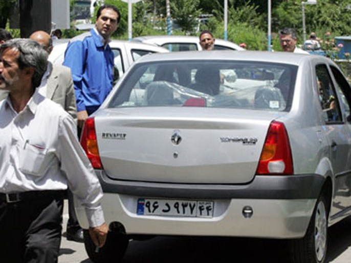 AFP/ Iranian men surround a Renault's Logan car, baptized in Iran as Tondar (thunder in Farsi) 13 June 2007 during a ceremony to deliver the first batch of Tondar 90 in Tehran.