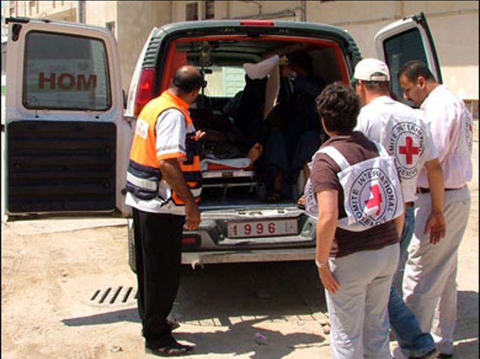 طاقم من الصليب يجهزون سيارة الإسعاف لنقل جريح الى إسرائيل من تقرير من غزة عن معاناة الجرحى الفلسطينيين.