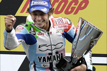 f_Italy's Valentino Rossi celebrates with the cup after wining the 125CC race at the Dutch Grand Prix in Assen, 30 June 2007. Italy's Valentino Rossi won ahead of Australia's Casey Stoner and USA's Nicky Hayden. AFP PHOTO MAARTJE BLIJDENSTEIN