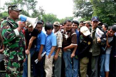 A soldier controls crowd of football fans lining up to buy tickts for the Asian Cup 2007 Group D match between Indonesia and Saudi Arabia outside the Bung Karno stadium in Jakarta, 13 July 2007