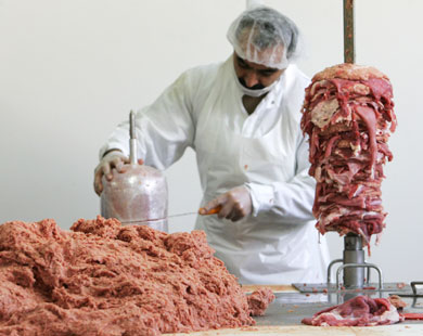 عامل يقطع اللحم المفروم (رويترز-أرشيف)