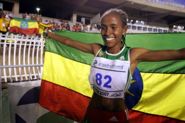 AFP/ Ethiopian Meseret Defar holds her national flag as she celebrates her gold medal 18 July 2007 in the Women's 5000 final at the 9th All-African-Games 2007 in Algiers.