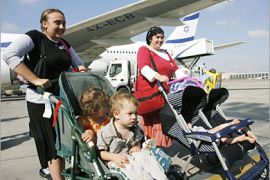 REUTERS /Jewish immigrants from North America walk in front of an airplane after landing at Ben Gurion International airport near Tel Aviv July 10, 2007. Some 200 Jews from North America