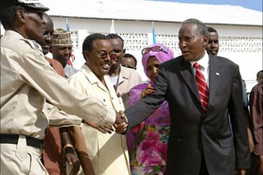r_Somali's President Abdullahi Yusuf Ahmed greets a police officer upon his arrival at the conference hall in Mogadishu July 15, 2007, where peace talks are due to begin. The