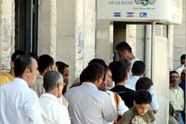 AFP / Palestinians queue to withdraw their salaries from an automatic teller machine in the northern West Bank city of Jenin, 04 July2007. After the Palestinian cabinet meeting two