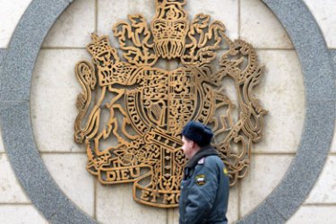 A file photo taken 12 December 2006 shows a Russian policeman passing by the Royal Coat of Arms on the wall of the British Embassy in Moscow. Russia will make an announcement later