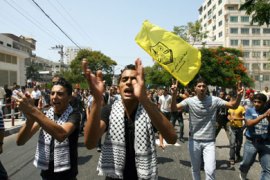 Wearing the trade mark Kefiyeh colours worn by the late Palestinian leader Yasser Arafat around their necks, Fatah movement members shout during a rally following Friday