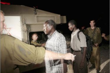 REUTERS/Sudanese refugees who illegally crossed into Israel are detained by Israeli soldiers at the border with Egypt