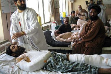 An Afghan doctor treats an injured man in Kandahar Hospital, 03 August 2007. At least 20 civilians were wounded and many others feared dead in an air strike by US-led forces