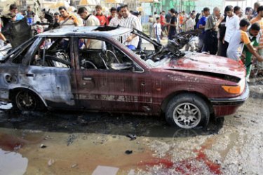 Iraqis inspect a damaged vehicle at the site of a car bomb in the predominantly Shiite Baghdad suburb of Sadr City, 20 August 2007. Four people were killed and another five injured