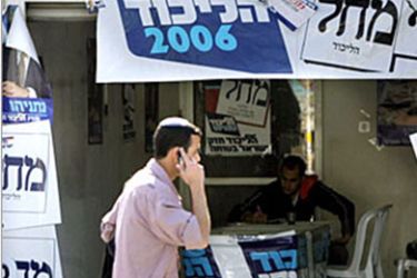 An Israeli man walks past campaign posters showing former Israeli Prime Minister and the head of Likud Party Benjamin Netanyahu, 16 March 2006 in Jerusalem. Israel's governing