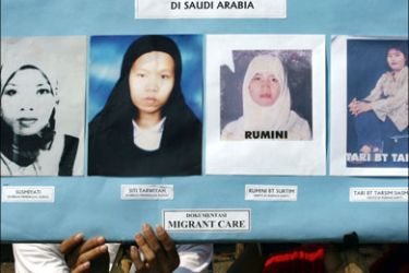 afp : Activists shows a placard displaying photos of Indonesian women migrant workers during a demonstration in front of Saudi Arabian embassy in Jakarta, 29 August