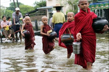 AFP : Myanmese Buddhist novices make their way through the flood waters to collect offerings in the flooded village of Athok, some 160 kilometers west of Yangon, 17 August