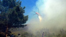 A helicopter drops water on a fire at Mount Taygete, on the Peloponnese Peninsula in Greece 24 August 2007. At least 15 people died today in two forest fires that raged