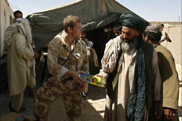 r_A British soldier hands a radio to an Afghan in a NATO base in Afghanistan's southern Helmand province September 27, 2007. REUTERS/Omar Sobhani