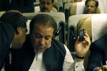 Former Pakistani prime minister Nawaz Sharif listens to a man onboard a Pakistani aircraft in London, September 10, 2007