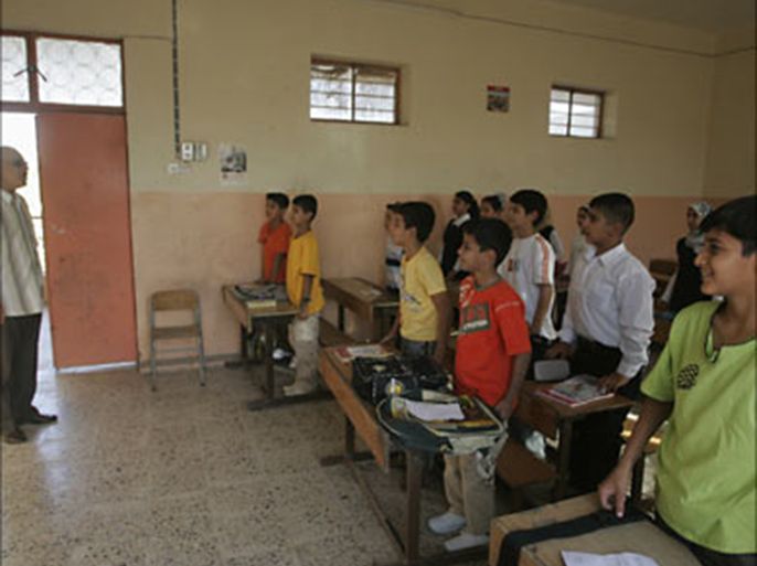 r_Students stand and greet their teacher on the first day of school in Baghdad September 30, 2007. For children in Iraq, the start of the new academic year on Sunday was