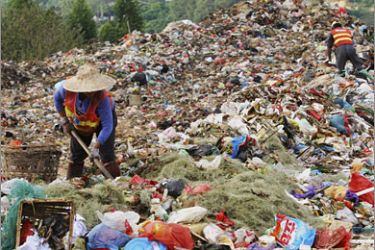 REUTERS/Workers clean up rubbish before burying at Dongfu rubbish landfill site in Xiamen, east China's Fujian province, October 24, 2007. The landfill site can process 2,000 tons of rubbish every day