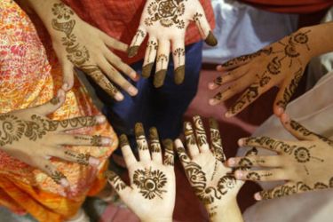Muslim girls show their henna decorated hands as a part of Eid-al-Fitr festival preparations in Karachi