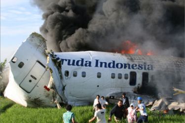 This file picture obtained by AFP on 09 March 2007 and was taken 07 March 2007 shows survivors fleeing from a Boeing 737-400 jet, belonging to the Indonesian flag carrier Garuda, which overshot the runway and caught fire after a rough landing at the airport in Yogyakarta. The pilots of the Garuda plane which crashed in Indonesia this year killing 21 people should face criminal charges, an Australian survivor of the disaster said 24 October 2007.