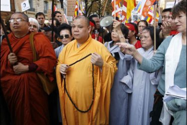 r/Britain's actress Jane Birkin (R) holds a candle as she demonstrates with Buddhist monks in support of democracy in Myanmar, near the embassy of China in Paris, October 6, 2007