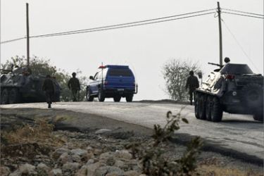 Turkish soldiers backed by armoured personnel carriers patrol as they search for possible roadside mines on a road in south eastern Turkish province of Sirnak, October 16, 2007