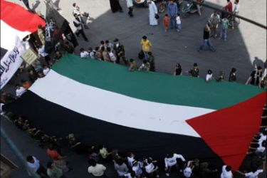r : Demonstrators carry a Palestinian flag during a rally to mark the Jerusalem Day at the Yarmuok refugee camp near Damascus October 5, 2007. REUTERS/Khaled al-Hariri