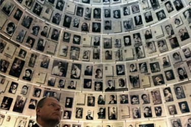 Germany's Finance Minister Peer Steinbrueck looks at pictures of Jews killed in the Holocaust during a visit to the Hall of Names at the Yad Vashem Memorial in Jerusalem November 22, 2007.