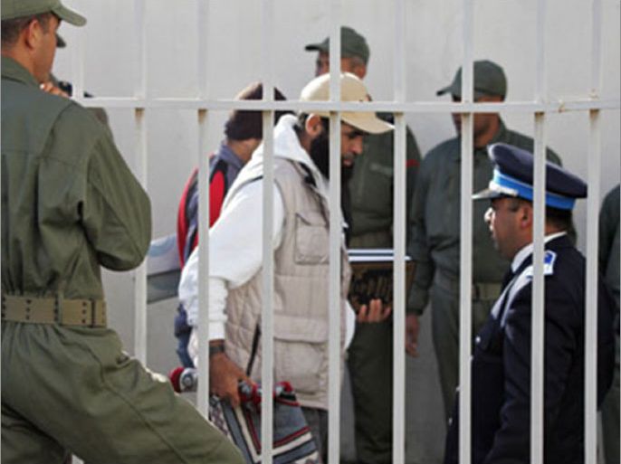 An Islamist prisoner walks, escorted by guards, 29 November 2007 prior being heard at Sale court, near capital Rabat. Eight Moroccan human rights groups decried abuses suffered by 360 Islamist detainees Sale's prison, calling for an urgent change in their living conditions, they said