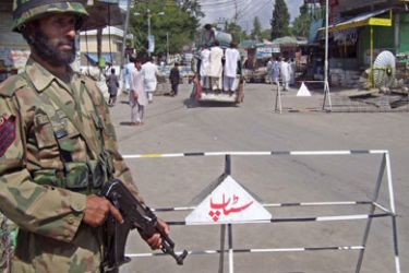 EPA/ epa01084685 Pakistani soldiers stand guard at a checkpoint in restive Parachinar in semi-autonomous Kurram tribal agency bordering Afghanistan 05 August 2007.