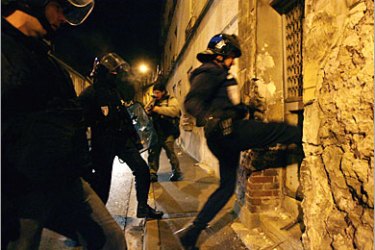 AFP / Riot police kick-in a door in the suburb of Villiers-le-Bel outside Paris 26 November 2007, where youths holed up during clashes in reaction to the deaths of two teenagers, Larami and Moushin, following a collision between the