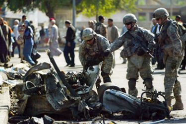 US soldiers inspect the wreckage at the site of a car bomb explosion in the northern district of Bab al-Muazzam in Baghdad