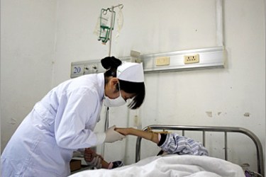 REUTERS/ A nurse during her morning rounds in the special HIV/AIDS ward comforts a patient after she administered medicine to her at the Beijing You An Hospital November 30, 2007 . An estimated 700,000 people are living with HIV/AIDS in China, with the rates of infections slowing this year. But China's efforts to prevent HIV/AIDS-related discrimination have failed