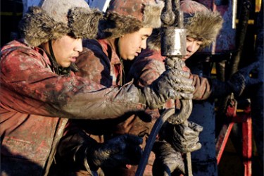 r/Oil field workers work at a well head in PetroChina's Daqing oil field in China's northeastern Heilongjiang province November 6, 2007. Chinese oil majors will push back