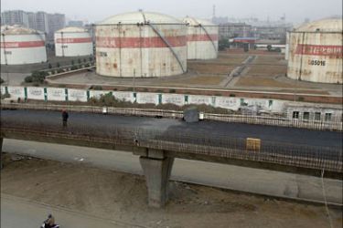r_Oil tanks are seen at a Sinopec plant in Hefei, Anhui province, December 4, 2007. China will require its oil firms to build their own reserves to supplement a government-owned