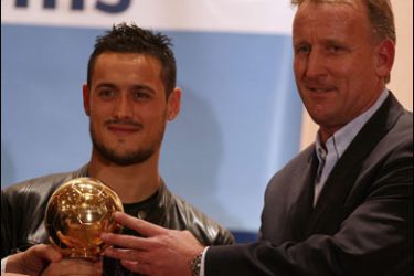 AFP PHOTO / Former German national football player Andreas Prehme (R) stands beside Algerian national football team player Kerim Ziani holding a 'Golden Ball' trophy for best Algerian player 2007 during a celebration organized by sports newspaper "Le Buteur" in Algiers City, 17 December 2007.