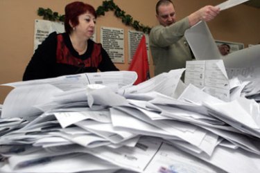 AFP/ Members of a local voting commission dump ballots onto a table to begin their vote count in Russia's parliamentary elections at a polling station in Moscow, 02 December 2007.