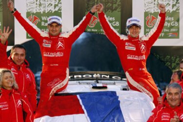 AFP/ Citroen driver Sebastien Loeb of France (top R) and his co-driver Monaco's Daniel Elena (top L) celebrate on the podium after securing the World Rally Championship after completing the Wales Rally GB 02 December 2007