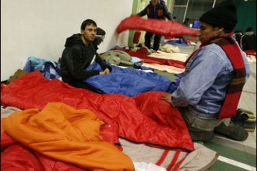 R/Afghan asylum seekers prepare to sleep at a shelter near the harbour of Calais December 23, 2007. The French port town of Calais opened a temporary shelter on Saturday to keep some 200 refugees from the streets in sub-zero winter cold. REUTERS/Pascal Rossignol (FRANCE)
