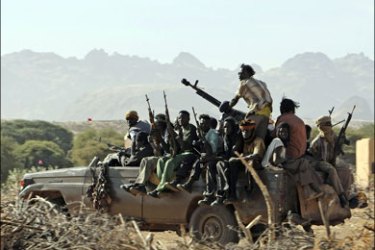 r : Fighters of the Sudan Liberation Army (SLA) sit on top of a truck in Korma village, some 40km (25 miles) outside the north Darfur town of Kutum, December 15, 2007. Picture