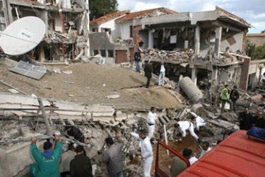 Algerian recue workers search through the rubble of a destroyed building near the United Nations refugee agency (UNHCR) offices
