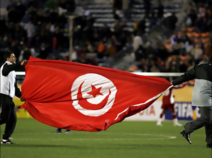 epa01195405 Tunisia's Etoile Sportive du Sahel staff members celebrate holding the Tunisian national flag after their team defeated Mexico's Pachuca at their FIFA Club