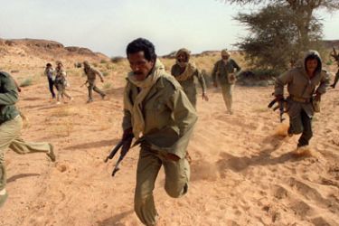 AFP/ (FILES) Polisario commandos scramble to take up positions near the front line with Morocco during an air-raid drill 14 June 1988 in Polisario-controlled Western Sahara. The Polisario Front threatened 21 December 2007