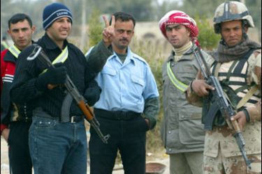 F/An Iraqi policeman (C) flashes a V-sign as he poses for a picture with members of Al-Sahwa, the so-called Iraqi Awakening Council, and an Iraqi soldier in the village of al-Hadid, on the outskirts of the restive city of Baquba northeast of Baghdad, 05 January 2008. Diyala, one of the most dangerous areas of the country, has been hit by a spate of shootings, suicide attacks and roadside bombings in recent days. AFP PHOTO / ALI YUSSEF