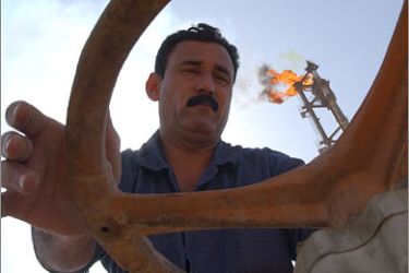 EPA/An undated file picture shows an oil worker opening an oil valve at an Iraqi refinery. The oil price has passed 100 dollars a barrel on world markets for the first