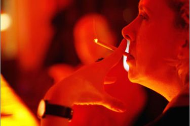 REUTERS/A woman smokes a cigarette inside the "Parallelwelt" bar in Hamburg's Altona district January 2, 2008. The owner of the bar avoids the smoking