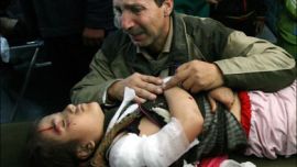 AFP - A Palestinian man kneels by his wounded daughter at Al-Shifa hospital in Gaza City 18 January 2008, follwing an Israeli raid that destroyed a building that used to house the